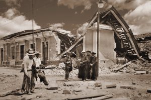 Foto antigua de personas frente a casa en ruinas